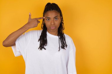 Mutsuz genç Afrikalı kadın intihar jesti yapıyor, her şeyden bıkıp, elinden vuruyor.