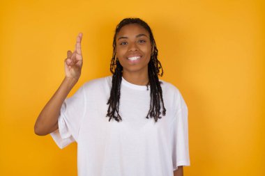 Saçları örgülü, genç, esmer bir kadın. Günlük kıyafetler giyiyor. Çince işaret diliyle on numarayı işaret ediyor.