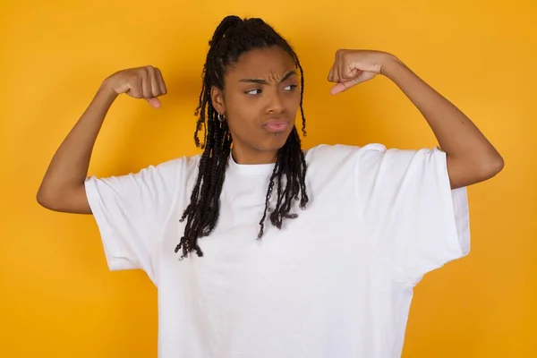 Afrikansk Amerikansk Kvinna Visar Muskler Gul Bakgrund — Stockfoto