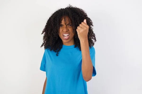 곱슬곱슬 머리의 아프리카 여자가 배경에 대해서 셔츠를 주먹을 나면서 소리를 — 스톡 사진
