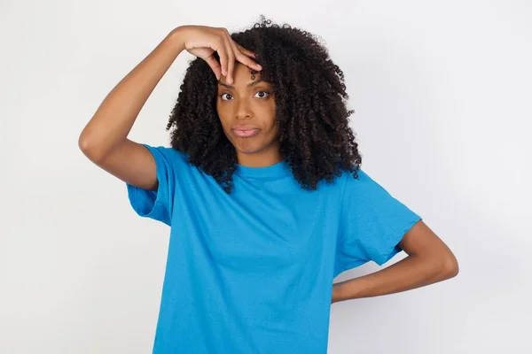 머리가 곱슬곱슬 아프리카 여자가 파란색 셔츠를 배경에 맞서서 문제가 걱정스럽고 — 스톡 사진