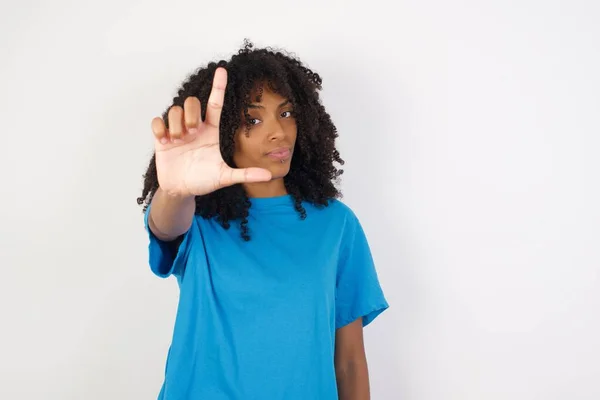 곱슬머리의 아프리카 여성이 파란색 셔츠를 배경에 맞서서 이마에 손가락을 사람들을 — 스톡 사진