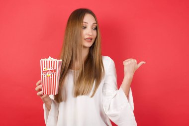 Patlamış mısırlı genç ve güzel bir kadın fotokopi odasına bakıyor. 