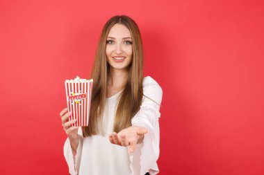 Patlamış mısırlı genç bir kadın yardım eli uzatıyor ve kabul ediyor..