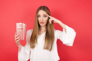 Patlamış mısırla alnını işaret eden genç ve güzel bir kadın. Bunu bir düşün..