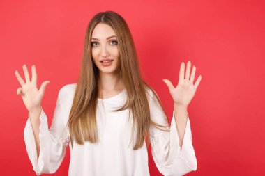 Genç ve güzel bir kadın dokuz numarayı gösterip işaret ederken kendinden emin ve mutlu gülümsüyor..