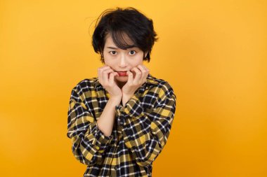 Güzel genç bir kadın ellerini ağzının yakınında tutuyor, korkmuş ve korkmuş hissediyor, fobisi var. Şok ve korku konsepti.