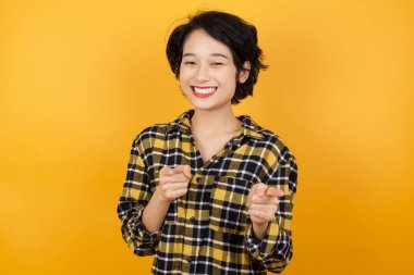 Güzel genç bir kadın mutlu ve komik yüzüyle kamerayı işaret ediyor. İyi enerji ve titreşimler. 