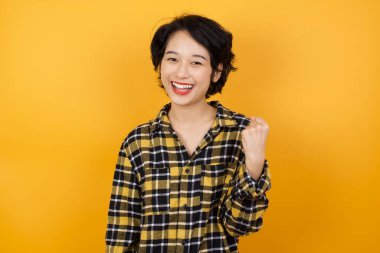 Güzel, genç bir kadın kaya hareketi yapıyor ve kameraya gülümsüyor. En sevdiği konsere gitmeye hazır..