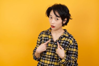 Güzel genç bir kadın, kafası karışmış bir ifadeyle rekabete katılmak için seçildiğini belirtir. Beyaz duvarda izole edilmiş bir şey hakkında tereddüt eder.