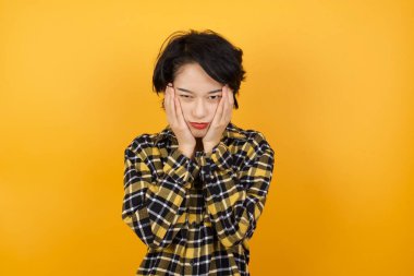 Güzel, genç bir kadın. Yorgun, yüzü, depresyonu ve üzüntüyü örten elleri var.