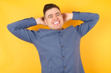 Yakışıklı genç işadamı kollarını uzatıyor, rahat bir konumda..