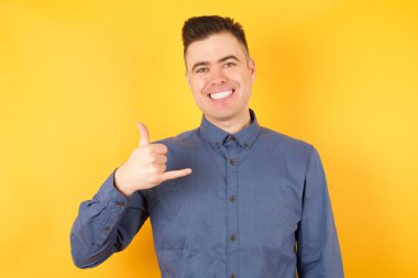 Yakışıklı genç işadamı el kol hareketi yapıyor. 