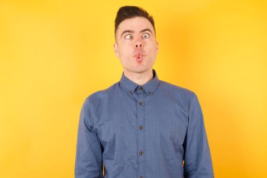 Yakışıklı genç iş adamı dudaklarıyla balık suratı yapıyor, çılgınca ve komik bir jest. Komik ifade.