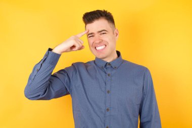 Yakışıklı genç işadamı alnındaki sivilceyi işaret ediyor, siyah nokta enfeksiyonu. Cilt bakımı kavramı.