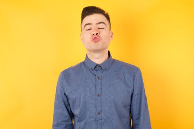 Yakışıklı genç iş adamı dudaklarını büzüyor. İnsan yüz ifadeleri