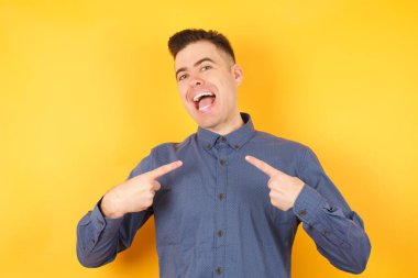 Yakışıklı genç işadamının gündelik gömleğine gösterdiği yatay poz. 