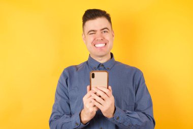 Akıllı telefonlu yakışıklı bir gencin portresi. 