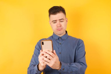 Akıllı telefonlu yakışıklı bir gencin portresi. 