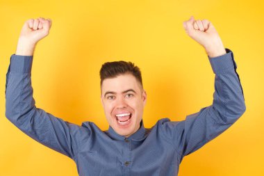 Elleri havada yakışıklı genç bir işadamı. 