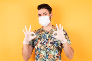 Koruyucu maskeli genç yakışıklı iyi hareketler gösteriyor.
