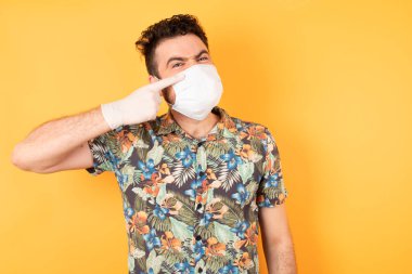 Koruyucu maskeli genç adam alnındaki sivilceden mutsuz siyah noktayı gösteren çirkin bir enfeksiyon. Sivilce ve deri problemi