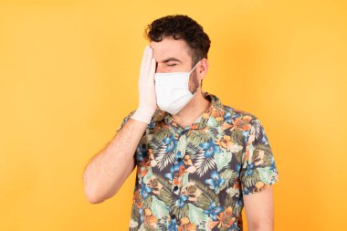 Koruyucu maskeli genç yakışıklı esneme yoruldu. Yarı yüz, göz ve ağzı eliyle kapatmaktan yoruldu. Yüzüm acıyor..