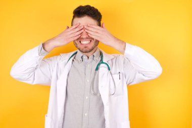 Genç yakışıklı, beyaz doktor üniforma giyiyor. Gözleri neşeli ve komik bir şekilde gülümsüyor. Kör kavram.