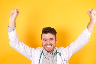 Bağıran yakışıklı beyaz doktor elleri havada sıhhiye üniforması giymiş adamın fotoğrafı. 