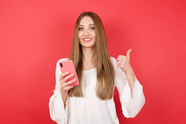 Portrét Mladé Krásné Ženy Chytrým Telefonem Pózování Červeném Pozadí Studia — Stock fotografie