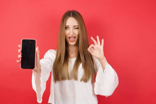Retrato Jovem Mulher Bonita Com Smartphone Posando Fundo Estúdio Vermelho — Fotografia de Stock