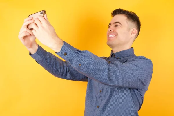 Knappe Jonge Man Poseren Met Smartphone Kleur Studio Achtergrond — Stockfoto