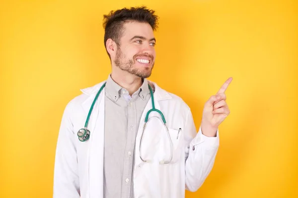身穿医疗制服 面带微笑的医生抬起头 从黄底朝外看去 — 图库照片