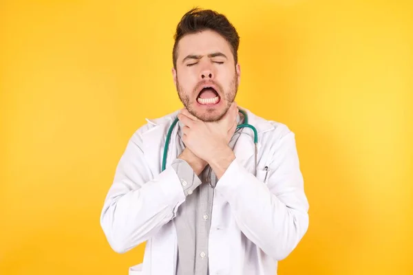 痛みを伴う奇妙なので 若いハンサムな白人医師の男性は 医療制服を着て窒息叫んでいます 健康上の問題 窒息と自殺の概念 — ストック写真