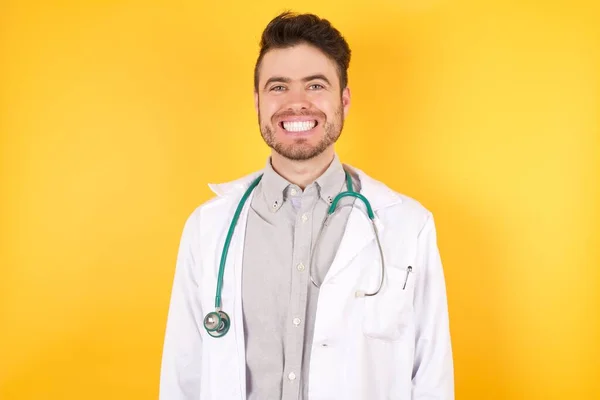 Homem Médico Caucasiano Jovem Vestindo Uniforme Médico Sobre Fundo Amarelo — Fotografia de Stock