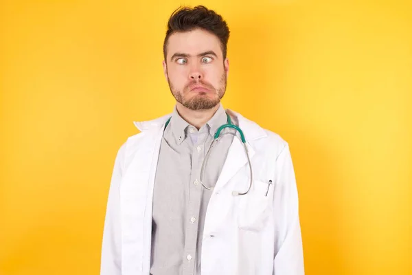 Portret Przystojnego Białego Lekarza Noszącego Mundur Medyczny Robiącego Grymas Szaloną — Zdjęcie stockowe