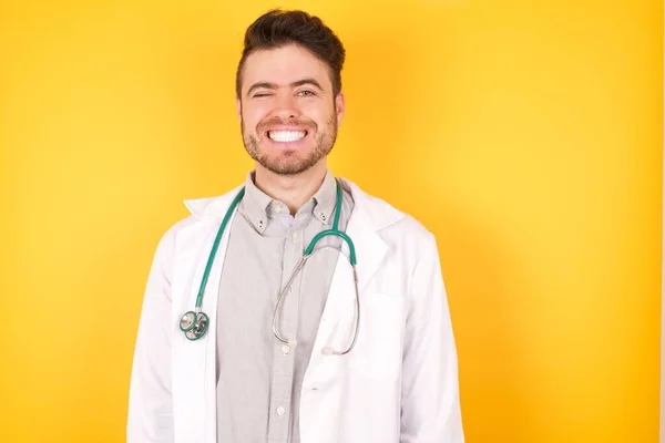 Studyjne Zbliżenie Pozytywnego Kokieteryjnego Białego Europejskiego Lekarza Uśmiechniętego Szczęśliwie Mrugającego — Zdjęcie stockowe