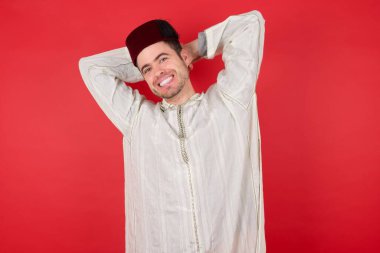 Geleneksel Türk şapkası takan yakışıklı genç adam kollarını açmış, rahat duruyormuş.. 