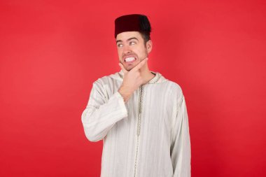 Geleneksel Türk şapkası giyen yakışıklı genç adam Fez bir soru hakkında endişeli ve gergin..