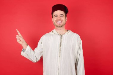 Geleneksel Türk şapkası takan yakışıklı bir gencin fotoğrafı.  