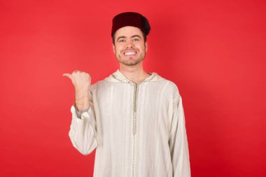 Geleneksel Türk şapkası giyen yakışıklı genç adam Fez fotokopi alanını gösteriyor.