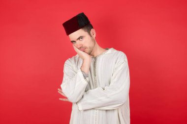 Fes takan çok sıkılmış yakışıklı bir genç adam.