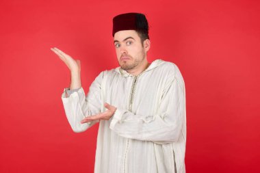 Yakışıklı iş adamı, iki elini de yana kaldırıp tuhaf bir şey gösteriyor ve söylüyor. Reklam kavramı.