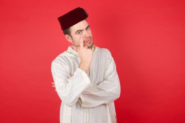 Fes takan yakışıklı genç adam senin jestini seyrediyor, şüpheli bir ifade.. 