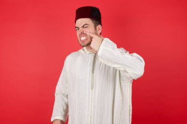 Geleneksel Türk şapkası takan yakışıklı genç adam alnındaki sivilceden mutsuz, siyah noktalı çirkin bir enfeksiyon taşıyor. Sivilce ve deri problemi