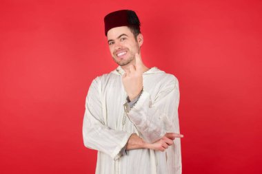 Geleneksel Türk şapkası giyen yakışıklı genç adam Fez Becking, gel buraya, el kol hareketi yap. 