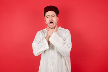 Geleneksel Türk şapkası giyen yakışıklı genç adam boğularak can çekişiyor çünkü boğularak can çekişiyor. Sağlık problemi. Boğulma ve intihar konsepti.