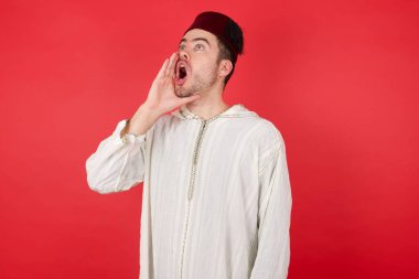 Geleneksel Türk şapkası takan yakışıklı genç adam el ele tutuşarak bağırıyor ve çığlık atıyordu. İletişim konsepti.