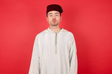 Geleneksel Türk şapkası takan yakışıklı genç adam. İnsan yüz ifadeleri
