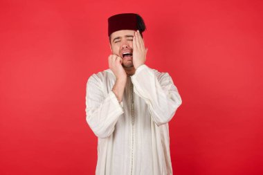 Depresyonda geleneksel Türk şapkası takan yakışıklı bir genç adam. Stresli görünüyor, somurtuyor. Yakışıklı erkek kendini yalnız ve endişeli hissediyor.